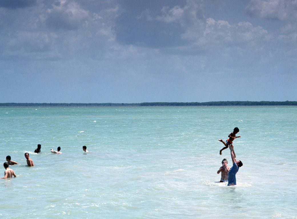 B9H2JE Group of children and adult playing in the Caribbean Sea Corozal, Belize, Central America