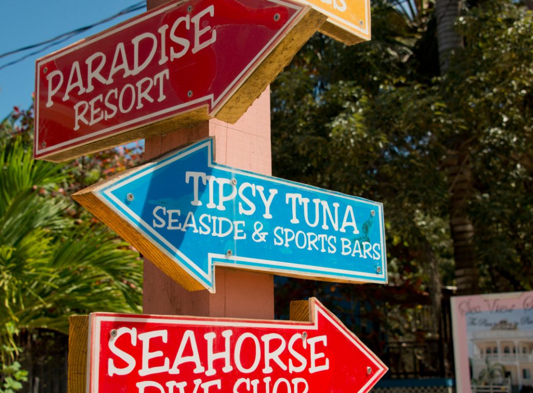 DWHAD4 Belize, Stann Creek District, Placencia. Colorful directional arrow signs.