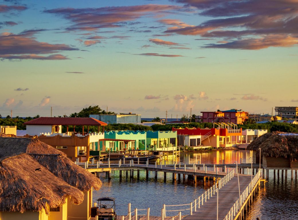 R2RY1R Over water cabanas and driveways stand out amid the colorful houses of San Pedro, Ambergris Caye, Belize at sunset.